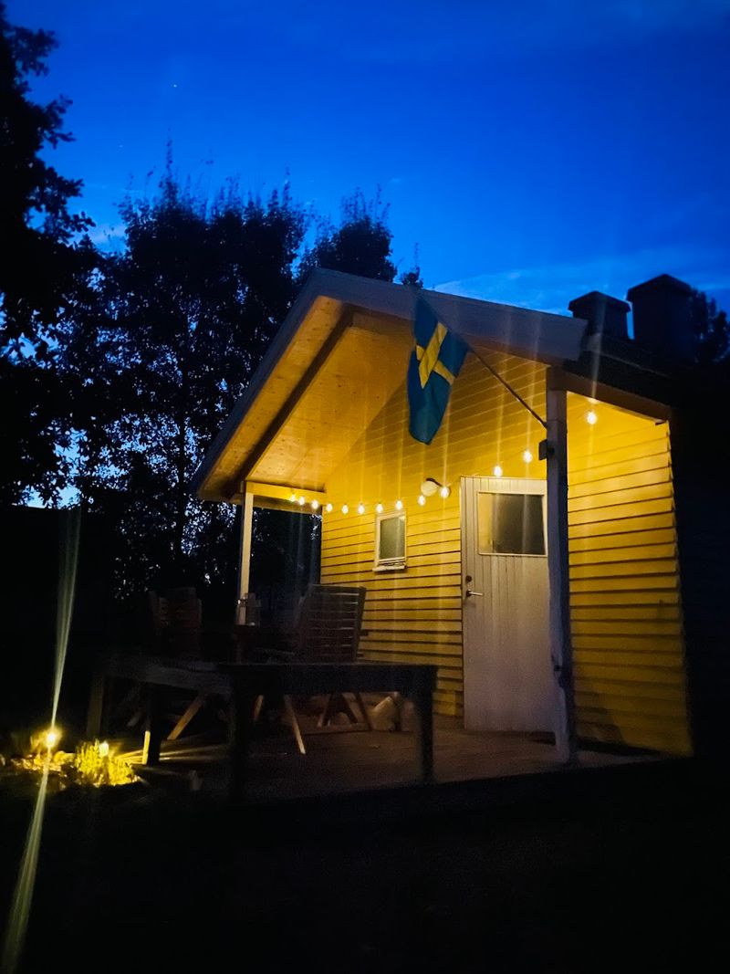 Stuga Eos mit Lichterketten an einem Sommerabend